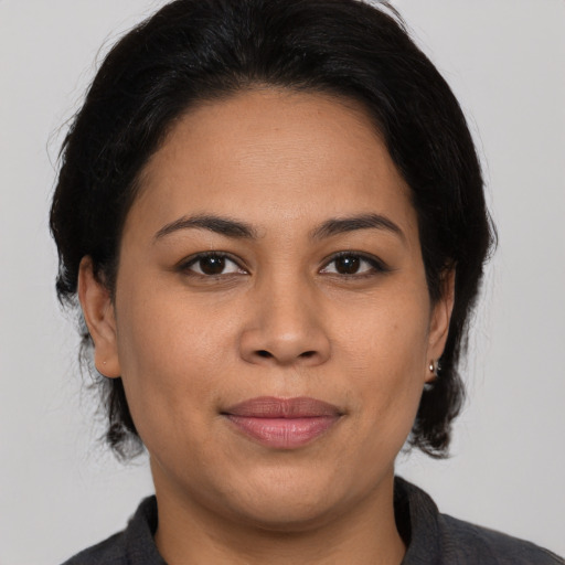Joyful latino young-adult female with medium  brown hair and brown eyes