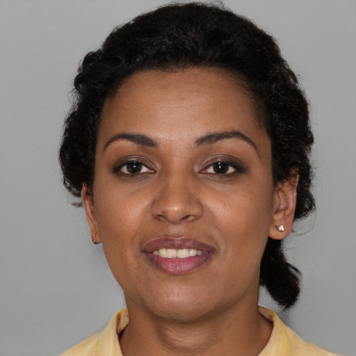 Joyful black young-adult female with short  brown hair and brown eyes