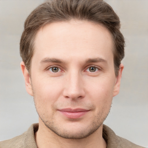 Joyful white young-adult male with short  brown hair and grey eyes