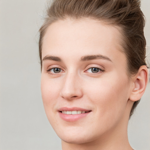 Joyful white young-adult female with short  brown hair and grey eyes