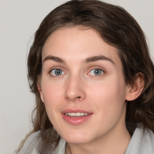 Joyful white young-adult female with medium  brown hair and green eyes