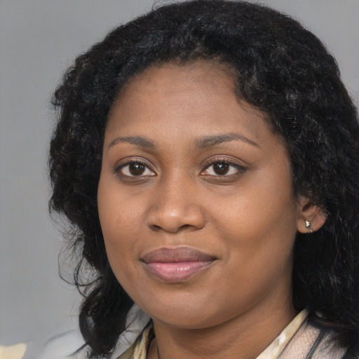Joyful black young-adult female with long  black hair and brown eyes