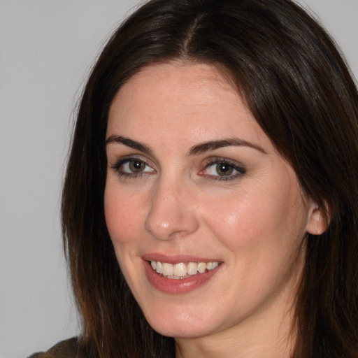 Joyful white young-adult female with long  brown hair and brown eyes