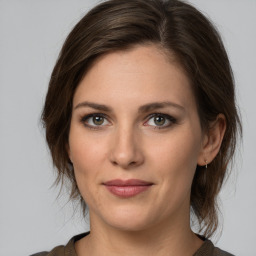 Joyful white young-adult female with medium  brown hair and green eyes