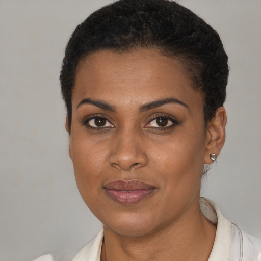 Joyful black young-adult female with short  black hair and brown eyes