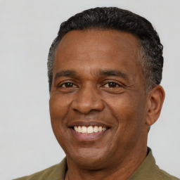 Joyful black adult male with short  black hair and brown eyes