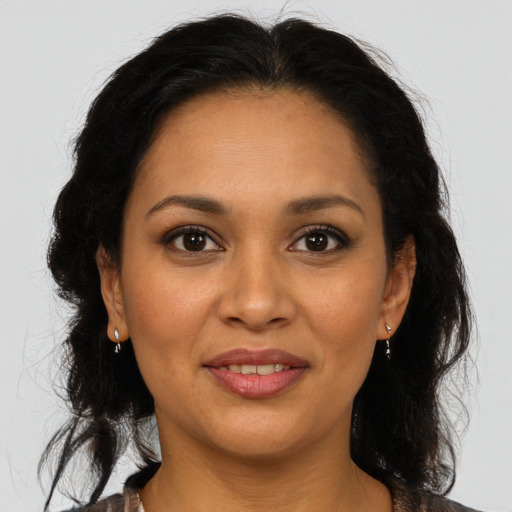 Joyful latino adult female with medium  brown hair and brown eyes