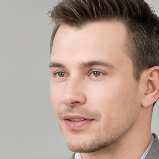 Joyful white young-adult male with short  brown hair and grey eyes