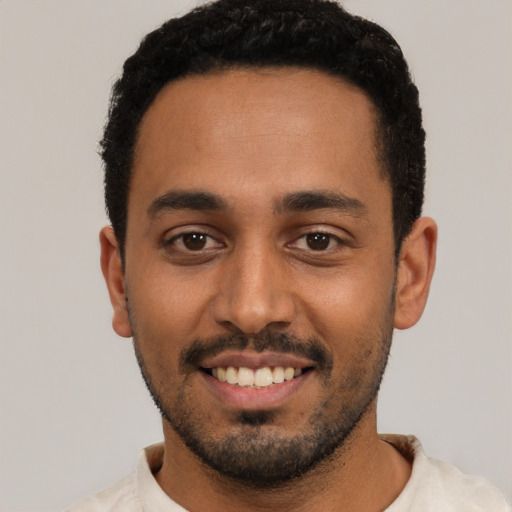 Joyful latino young-adult male with short  black hair and brown eyes