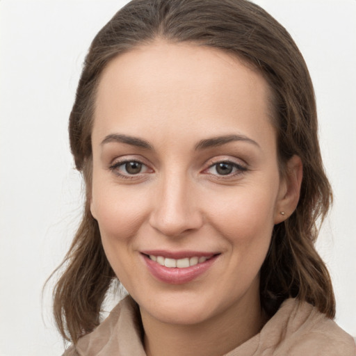 Joyful white young-adult female with medium  brown hair and grey eyes