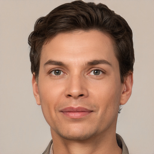 Joyful white young-adult male with short  brown hair and grey eyes