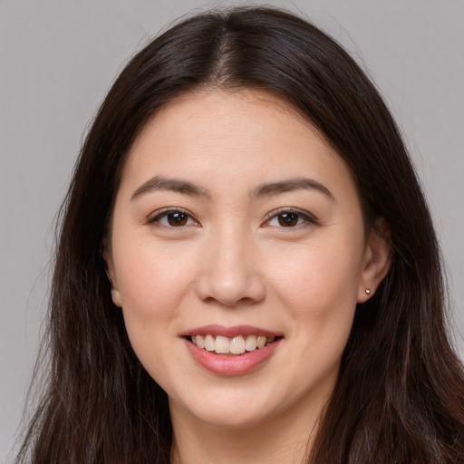 Joyful white young-adult female with long  brown hair and brown eyes