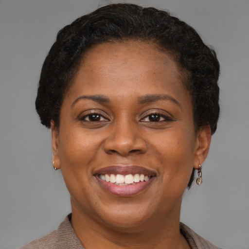 Joyful black adult female with short  brown hair and brown eyes