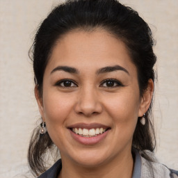 Joyful latino young-adult female with medium  brown hair and brown eyes