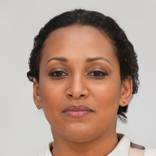 Joyful black adult female with short  brown hair and brown eyes