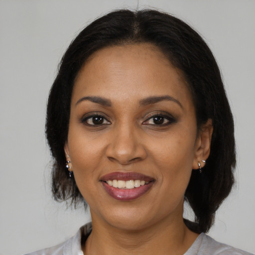 Joyful black adult female with medium  brown hair and brown eyes