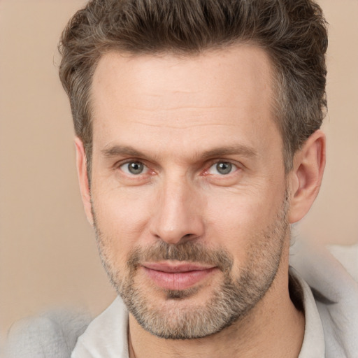 Joyful white adult male with short  brown hair and brown eyes