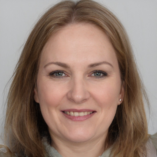 Joyful white adult female with long  brown hair and grey eyes