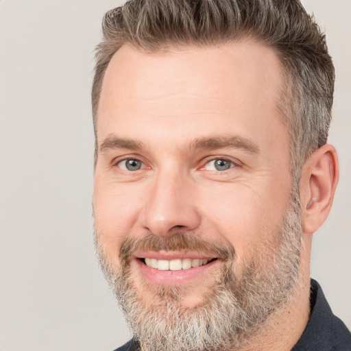 Joyful white adult male with short  brown hair and brown eyes