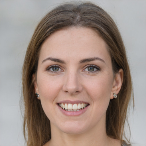 Joyful white young-adult female with long  brown hair and grey eyes