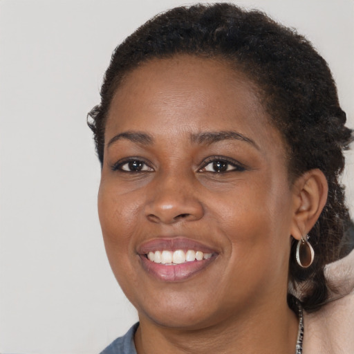 Joyful black young-adult female with short  brown hair and brown eyes