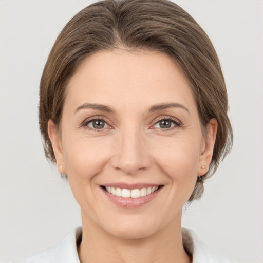 Joyful white young-adult female with medium  brown hair and grey eyes