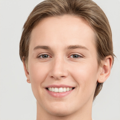 Joyful white young-adult female with short  brown hair and grey eyes