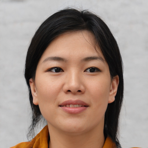 Joyful asian young-adult female with medium  brown hair and brown eyes