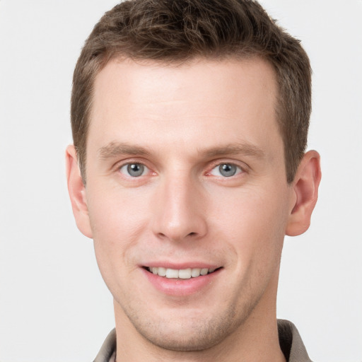 Joyful white young-adult male with short  brown hair and grey eyes