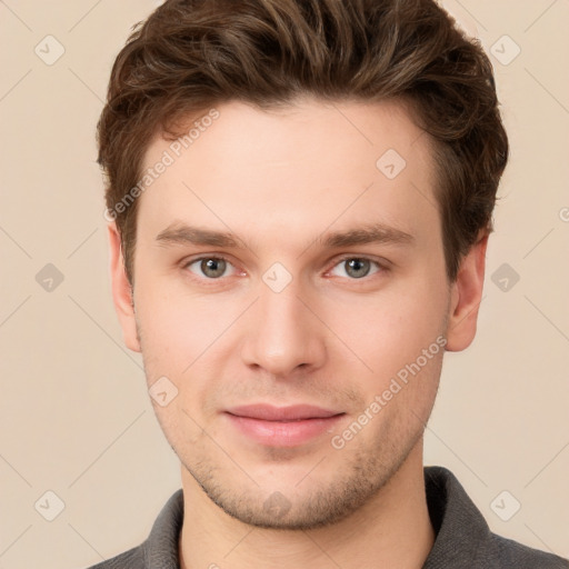 Joyful white young-adult male with short  brown hair and grey eyes