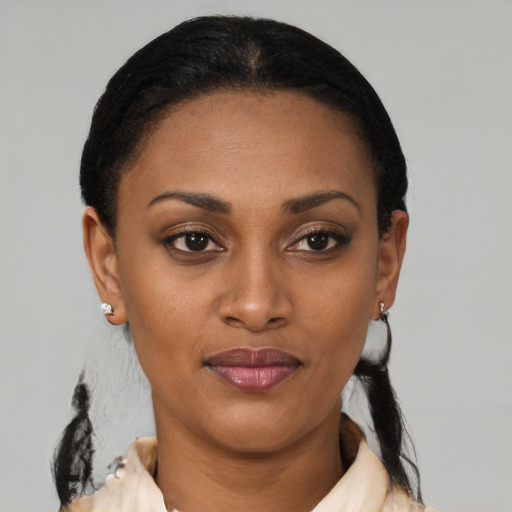 Joyful black young-adult female with short  black hair and brown eyes