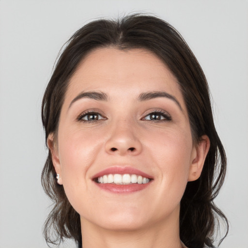 Joyful white young-adult female with medium  brown hair and brown eyes