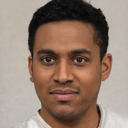 Joyful latino young-adult male with short  black hair and brown eyes