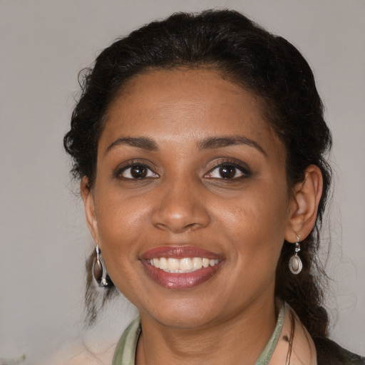Joyful black adult female with medium  brown hair and brown eyes