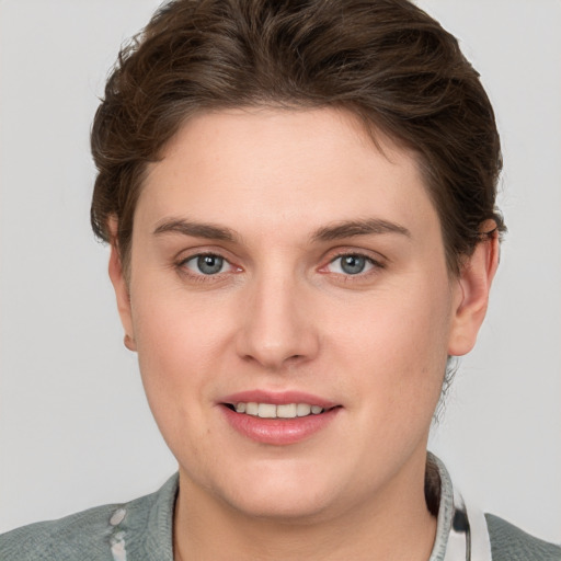 Joyful white young-adult female with short  brown hair and grey eyes