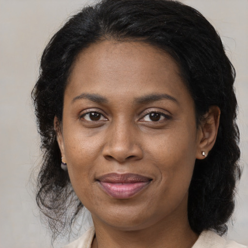 Joyful black adult female with medium  brown hair and brown eyes