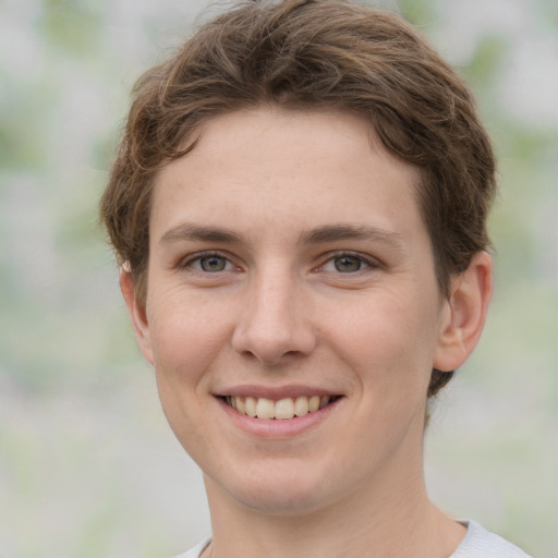 Joyful white young-adult female with short  brown hair and green eyes