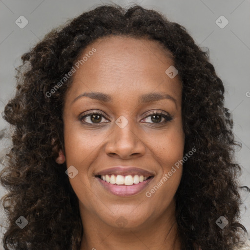 Joyful black young-adult female with long  brown hair and brown eyes