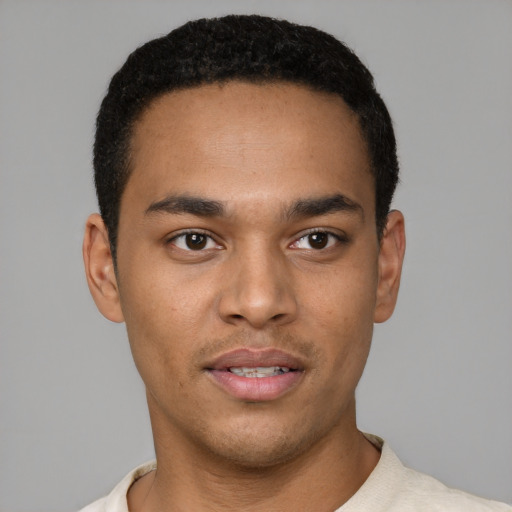 Joyful black young-adult male with short  brown hair and brown eyes