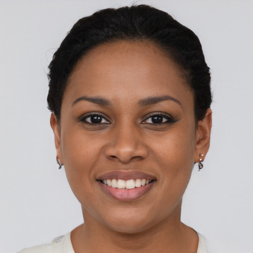 Joyful black young-adult female with short  black hair and brown eyes