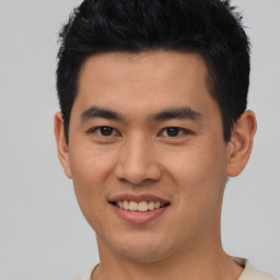 Joyful asian young-adult male with short  black hair and brown eyes