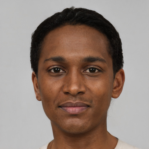 Joyful black young-adult male with short  black hair and brown eyes
