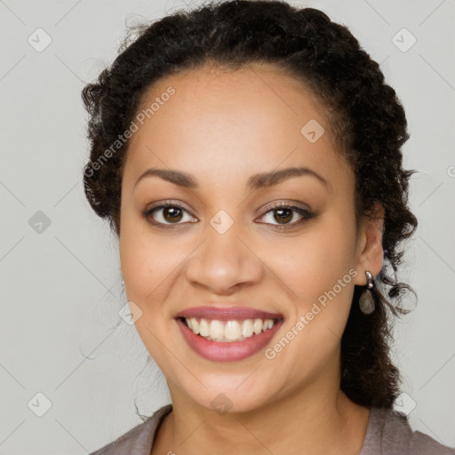 Joyful black young-adult female with long  brown hair and brown eyes