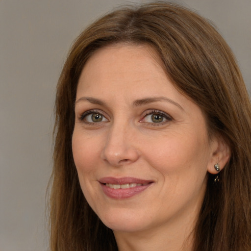 Joyful white adult female with long  brown hair and brown eyes