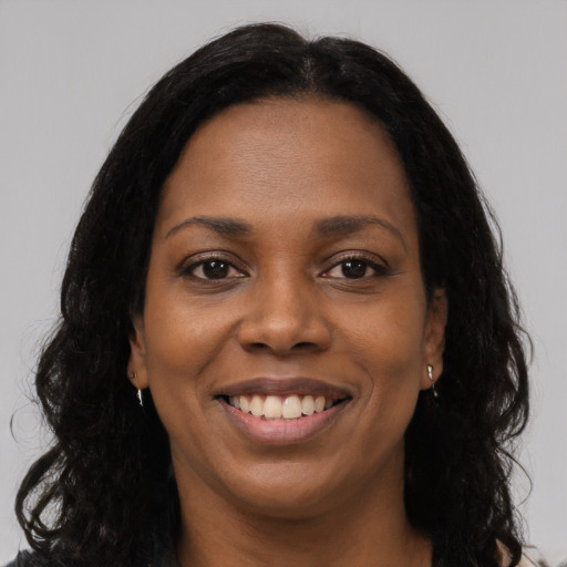 Joyful black young-adult female with long  black hair and brown eyes