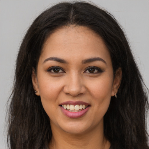 Joyful latino young-adult female with long  brown hair and brown eyes