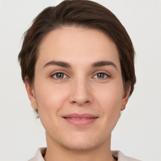 Joyful white young-adult female with short  brown hair and grey eyes