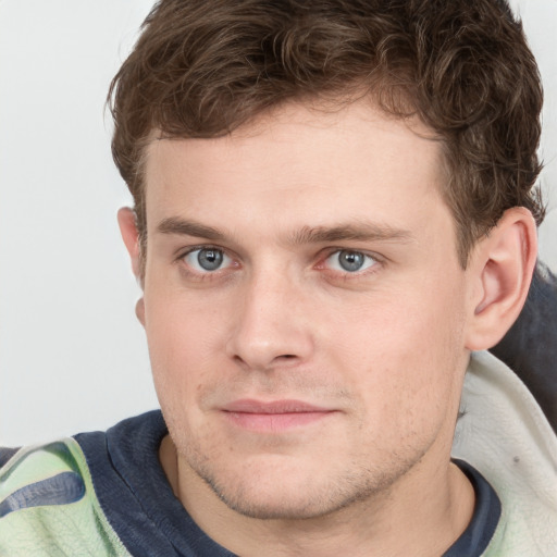 Joyful white young-adult male with short  brown hair and blue eyes