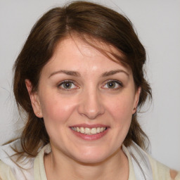 Joyful white young-adult female with medium  brown hair and blue eyes