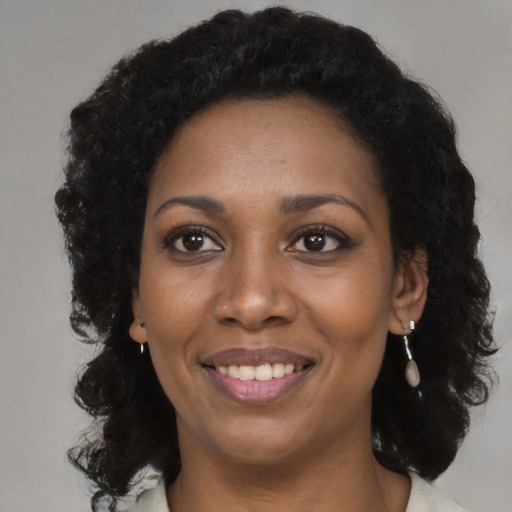Joyful black young-adult female with medium  black hair and brown eyes